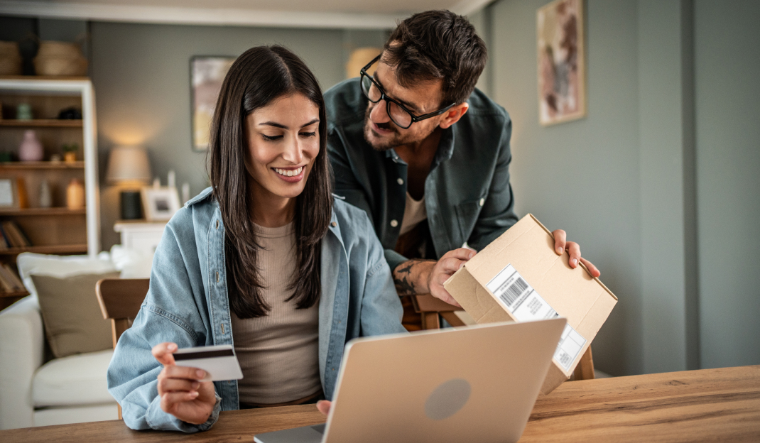 Una giovane coppia intenta a finalizzare un nuovo acquisto online tramite un computer